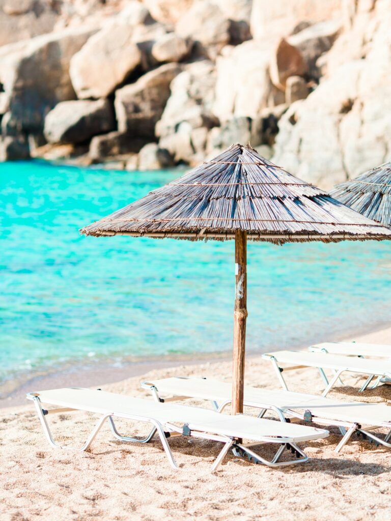 Beach wooden chairs and umbrellas for vacations on beach in Greece